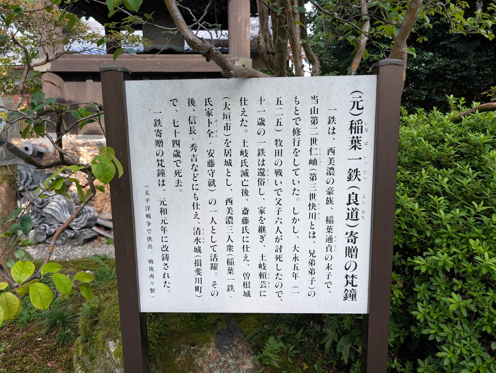 鐘楼の脇の説明板。末尾に梵鐘の供出が書かれている