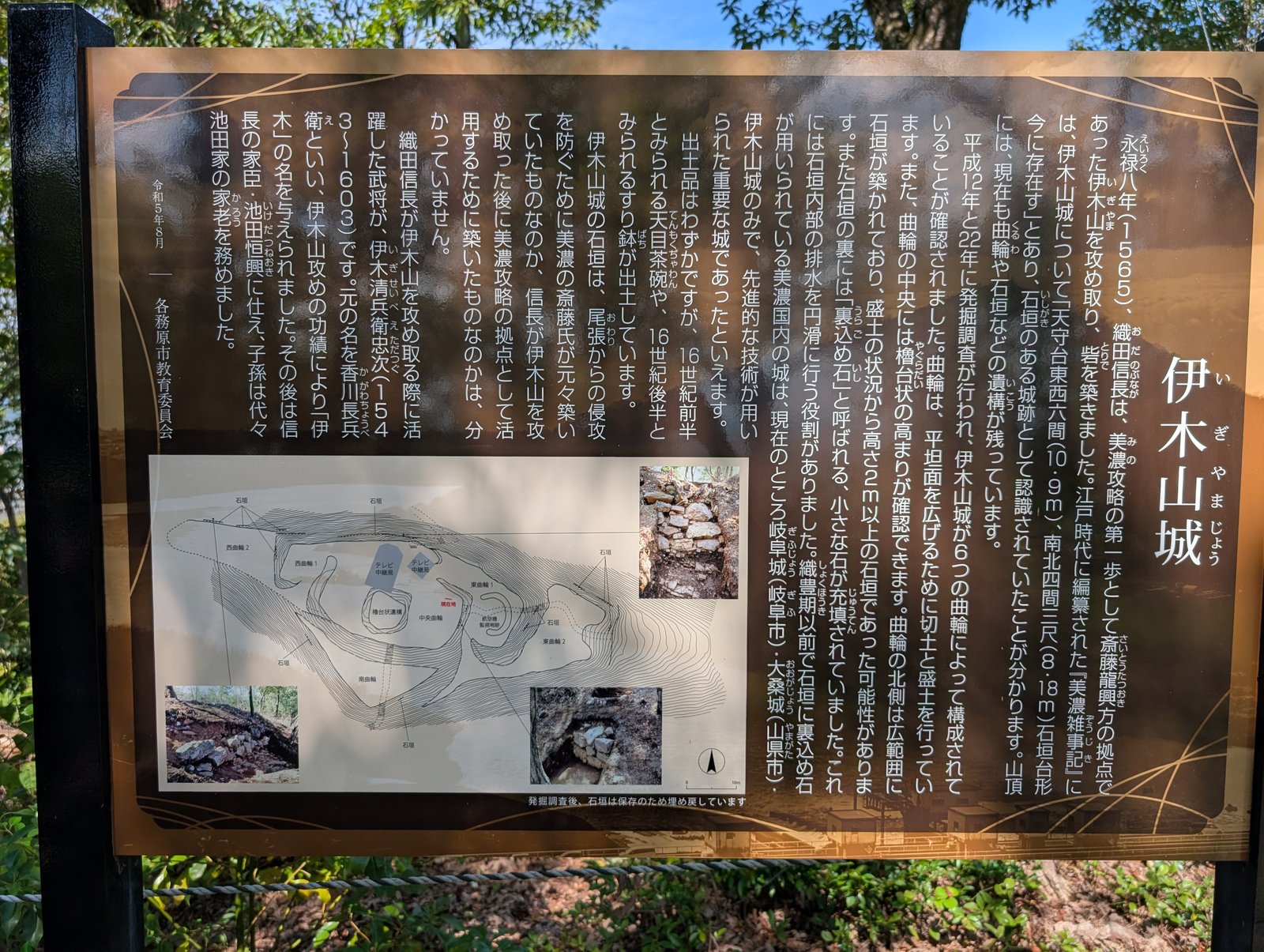 山頂の説明板「伊木山城」。縄張図と発掘写真が並ぶ（2026年9月撮影）