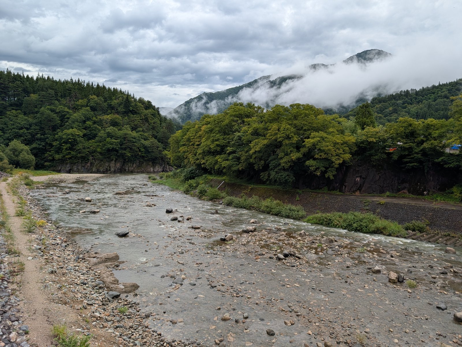 庄川の河原。マップはここを「綿流し祭」のモデルとなった場所とし、河原は足場が悪いので土手や橋の上から見るよう添えている（2026-08-27 撮影）