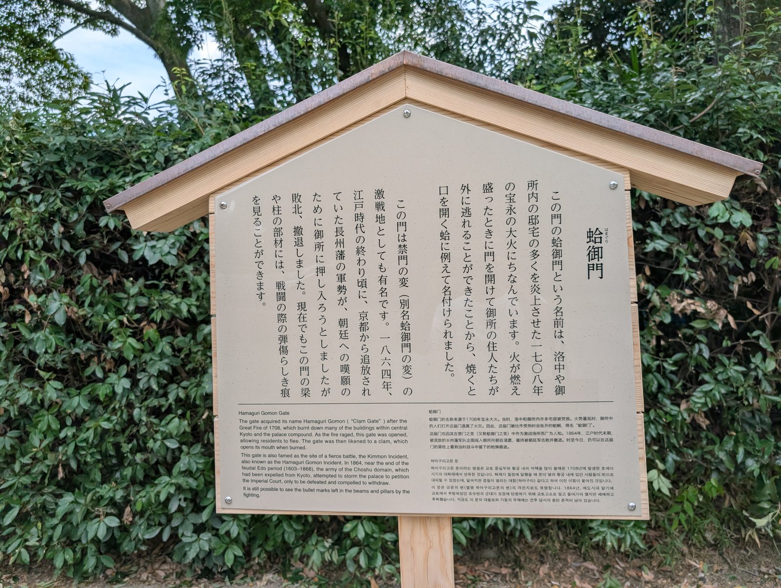 門の説明板。「梁や柱の部材には、戦闘の際の弾傷らしき痕を見ることができます」とある