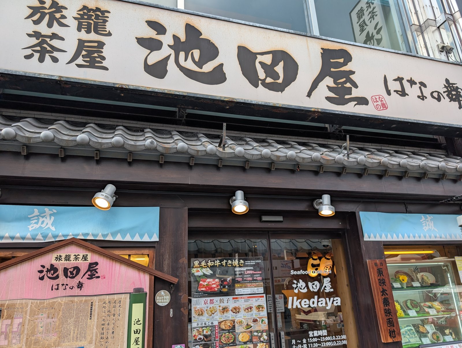 店先の看板「旅籠茶屋 池田屋 はなの舞」。両脇に「誠」の幟が下がる