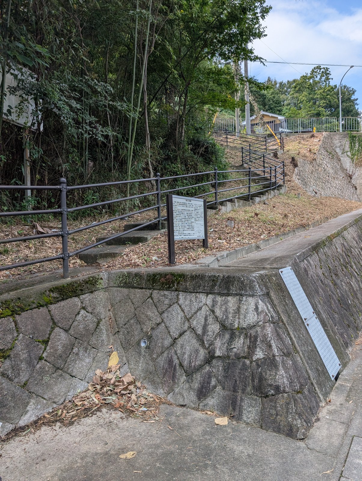 説明板が立つ、峠道沿いの斜面