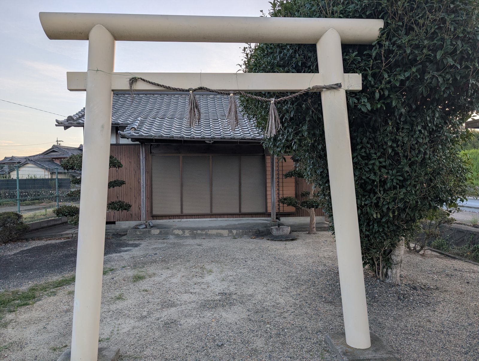 同じ鳥居を斜めから。奥に瓦屋根の小さな建物