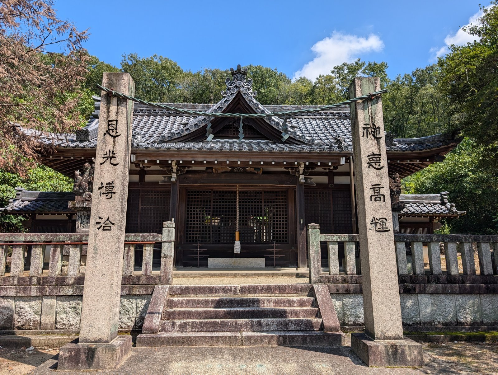 熊野神社の社殿。瓦葺きの拝殿と石の玉垣（2026年9月撮影）