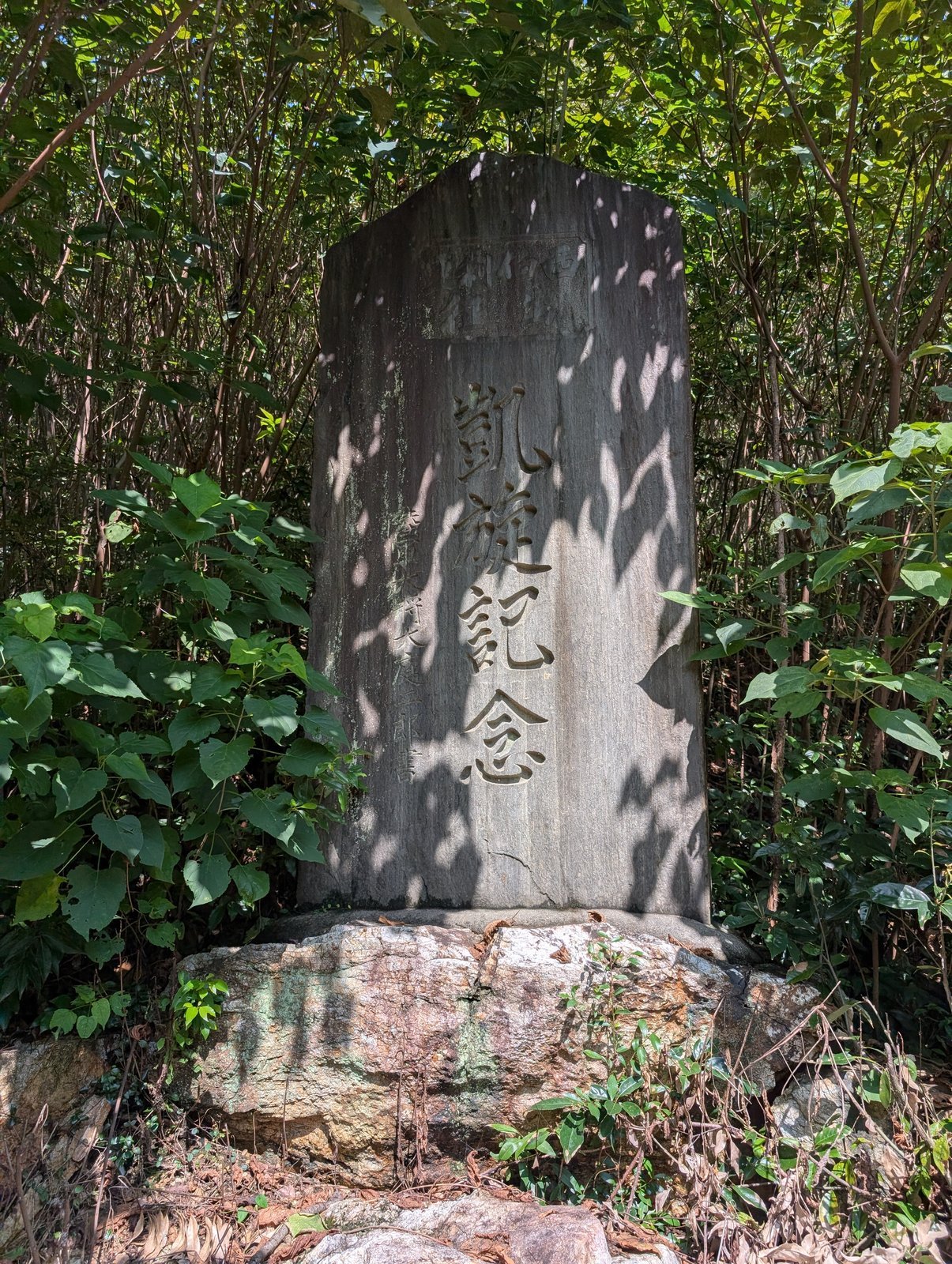 藪に沈みかけた「凱旋記念」の碑（2026年9月撮影）