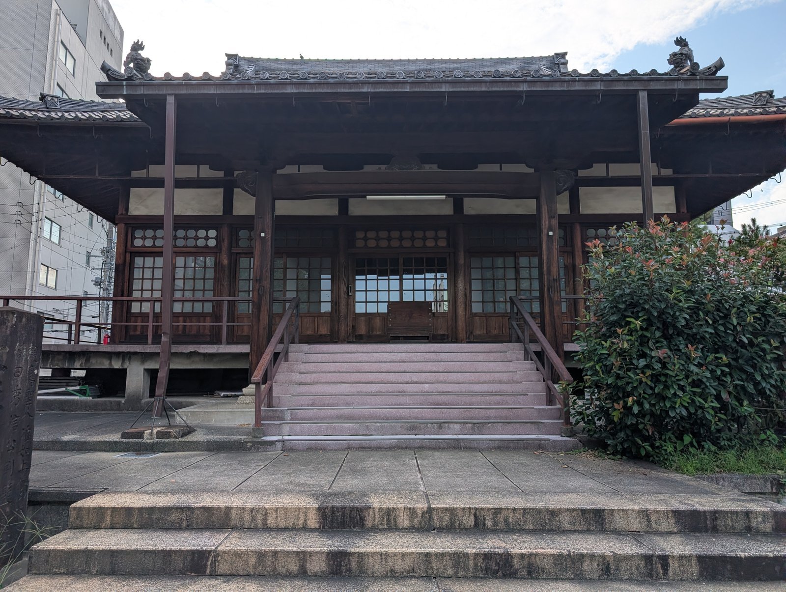 円徳寺の本堂。左右にビルが迫り、電線が横切る（2026年9月撮影）